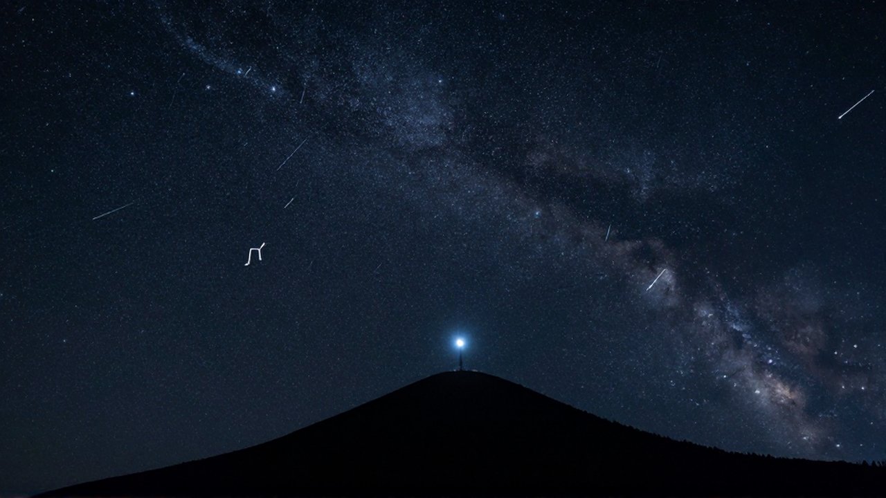 Cielo nocturno despejado sobre una montaña con la estrella Polaris y las constelaciones de la Osa Mayor y Casiopea.