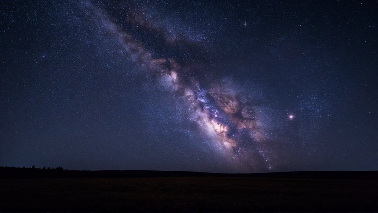 Cielo nocturno despejado sobre un paisaje austral con la Vía Láctea y la Cruz del Sur.